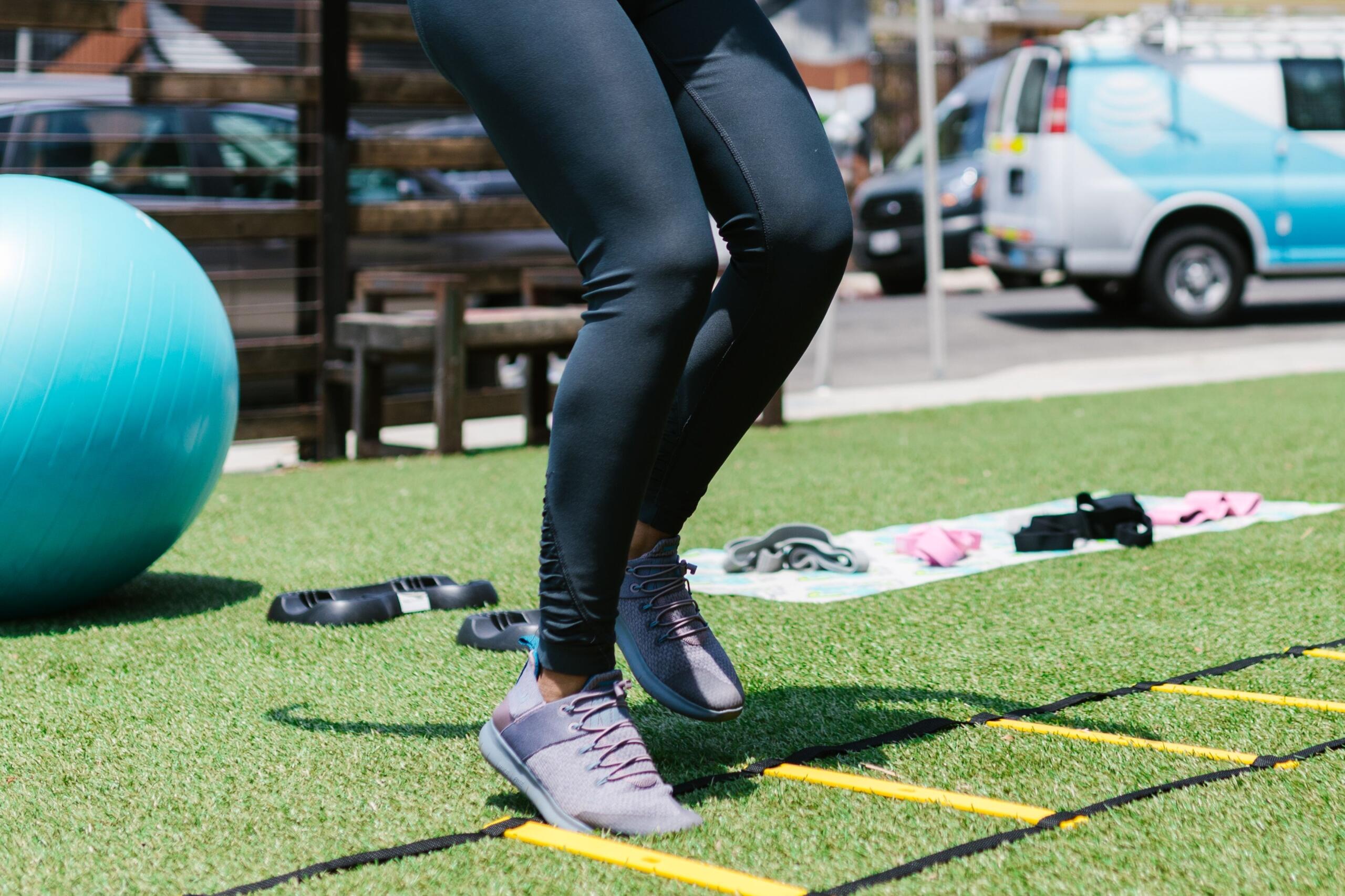 An athlete performs agility exercises, moving quickly through a footwork drill with focused precision during a speed and coordination workout.