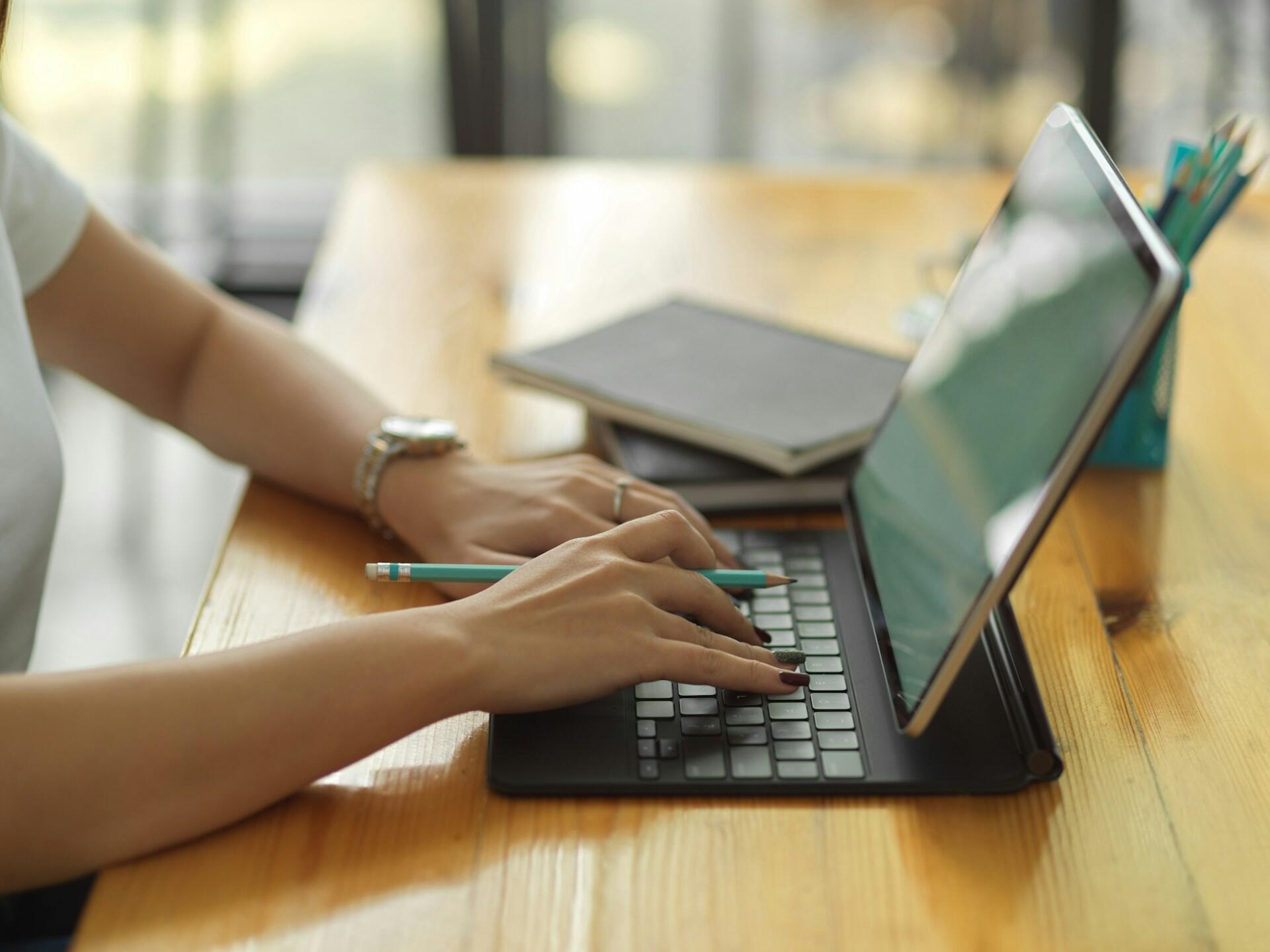 person using a laptop computer at a desk in a bright room