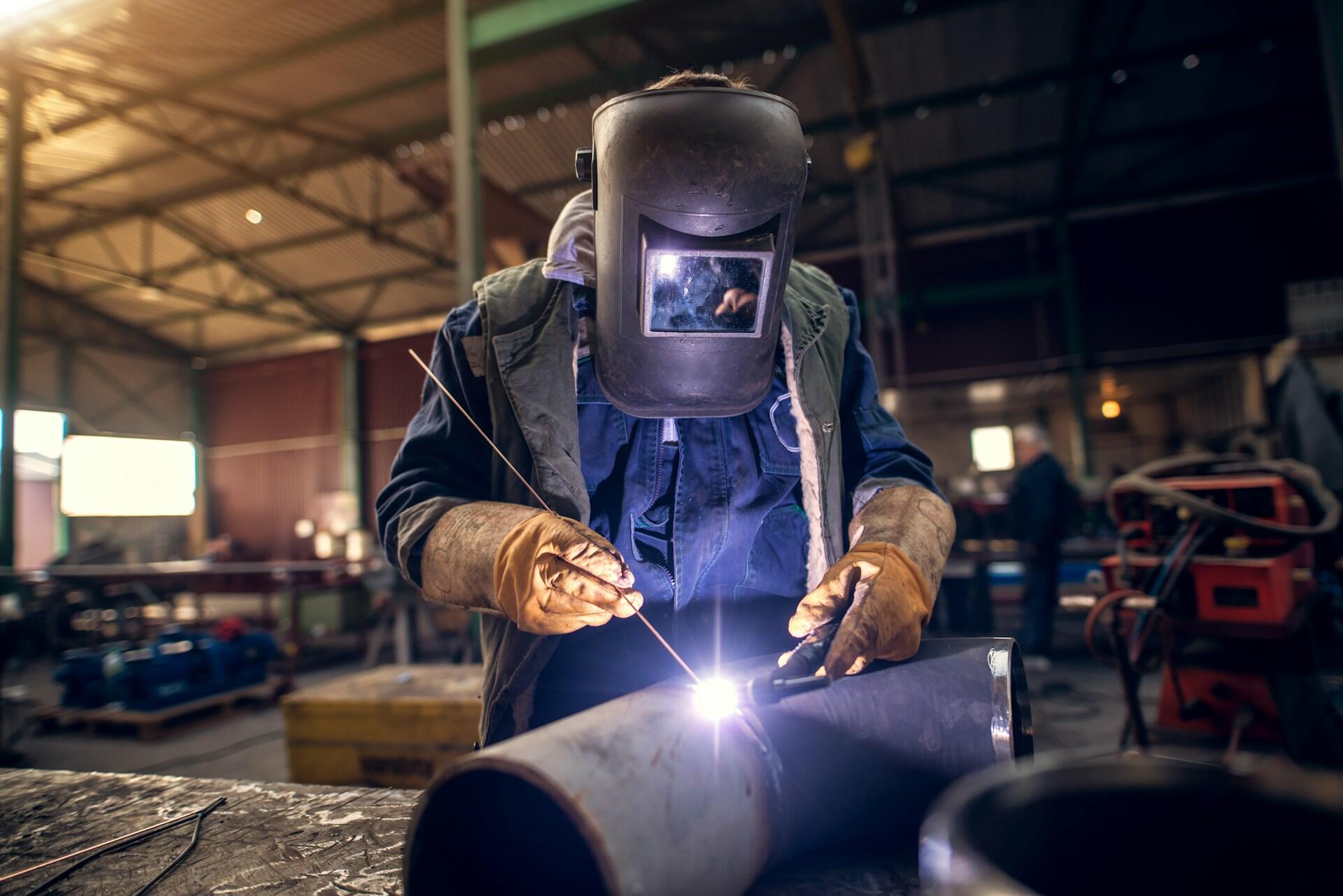 a welder working on soldering a large metal pipe