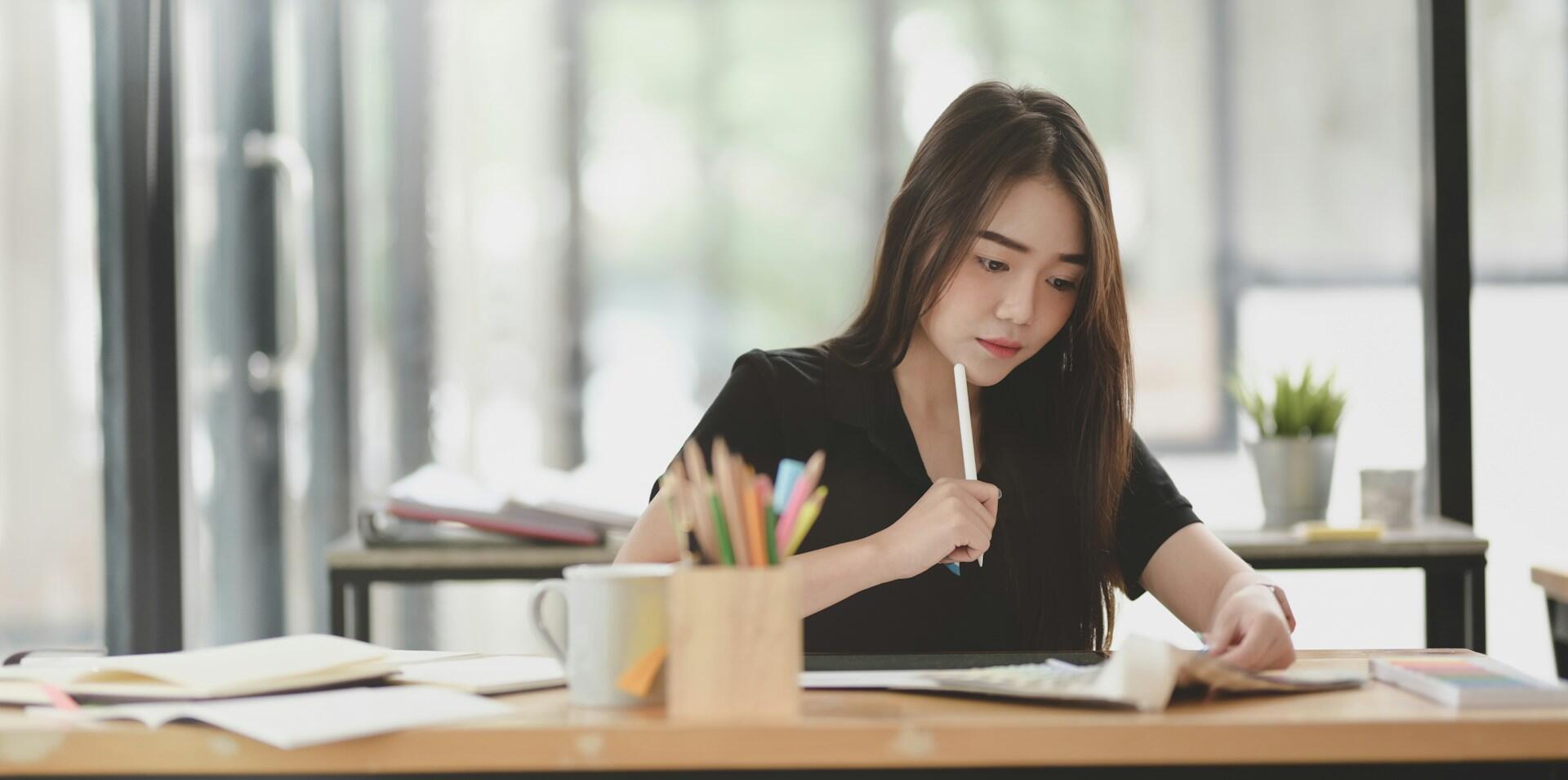 a candidate practicing writing in a well-lit room on a modern desk