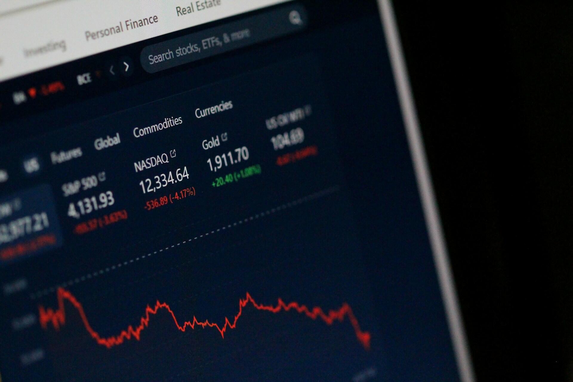 computer screen showing a financial chart with a red, decreasing line