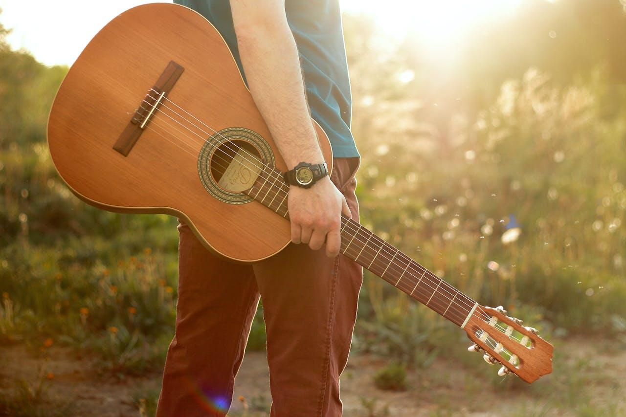 homme dans la nature ensoleillee avec guitare