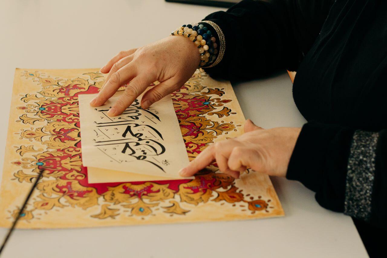 femme effectuant de la calligraphie arabe