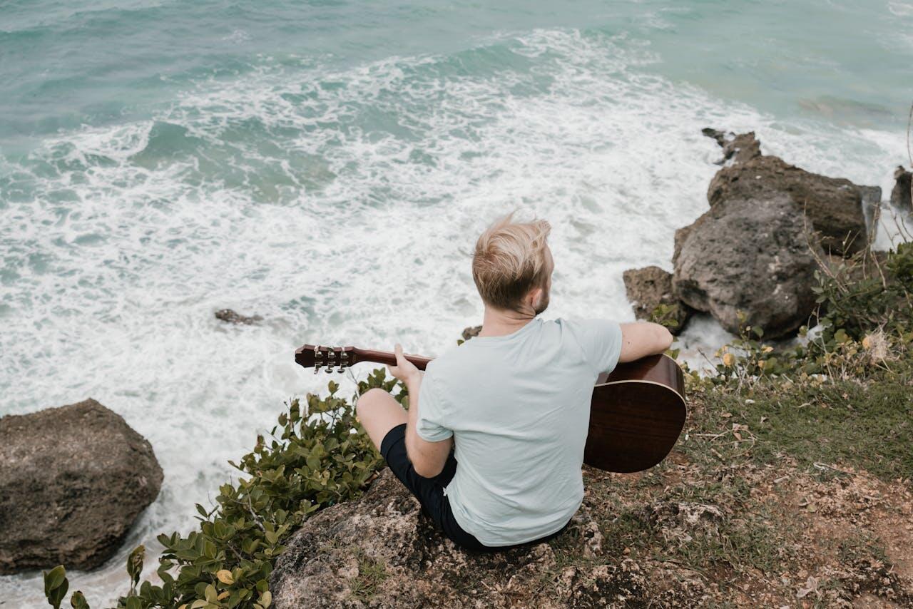 homme jouant de la guitare au bord de la mere