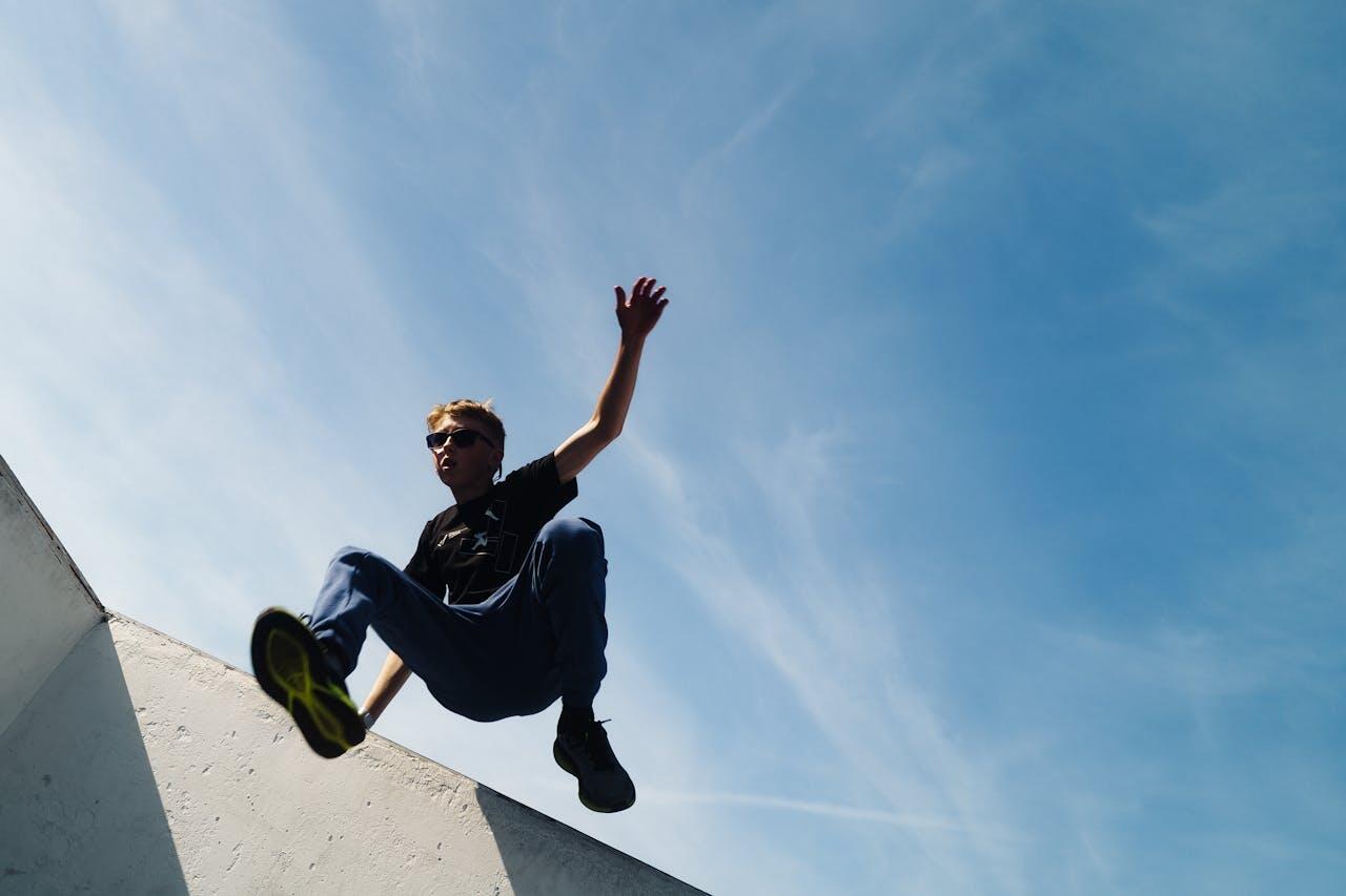 jeune homme sous un ciel bleu sautant