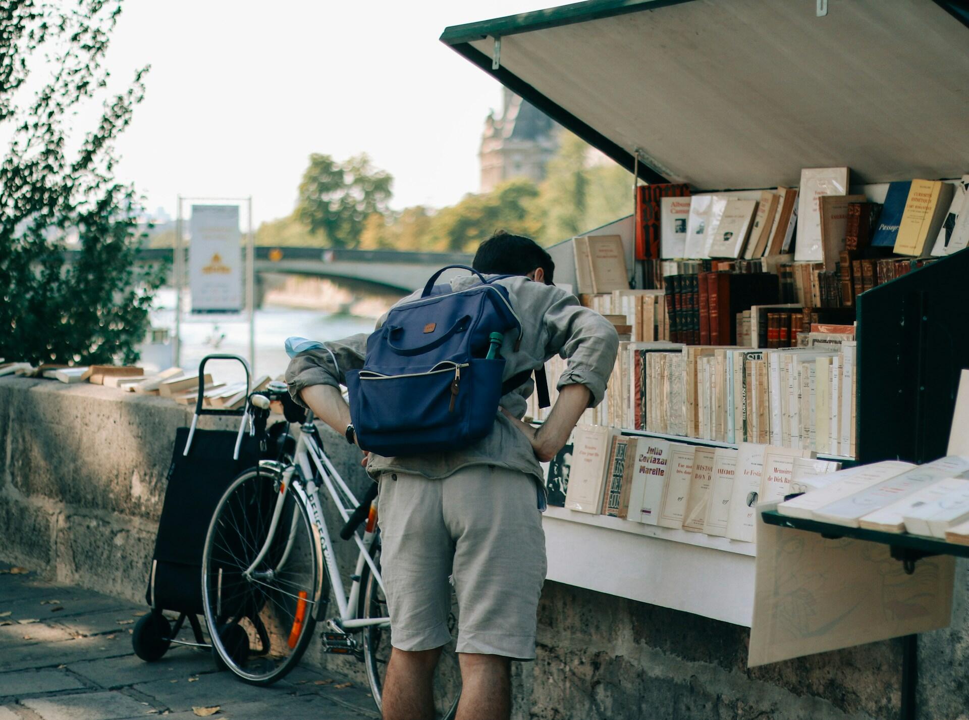 Individu qui regarde un stand de livres.