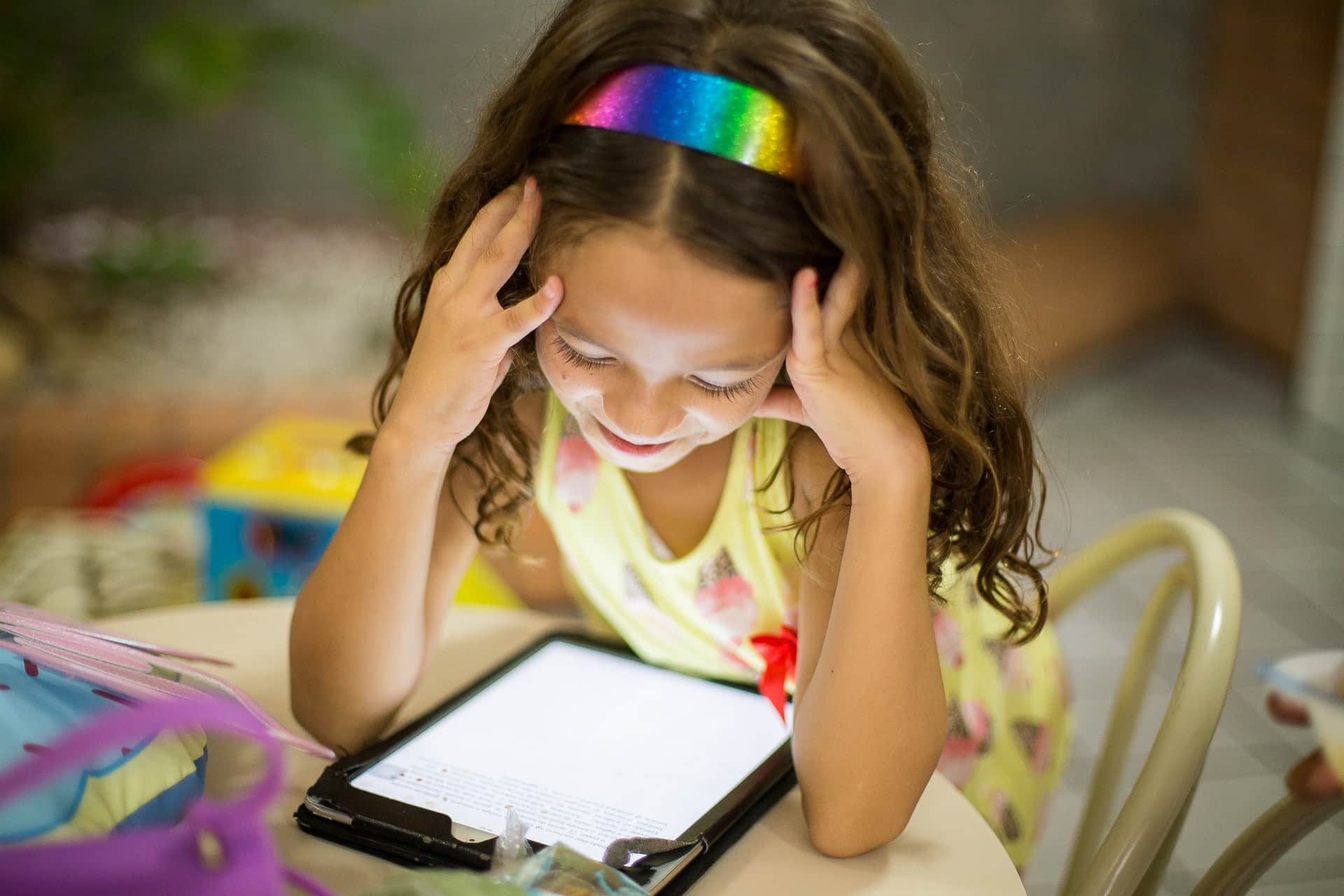une petite fille devant sa tablette.