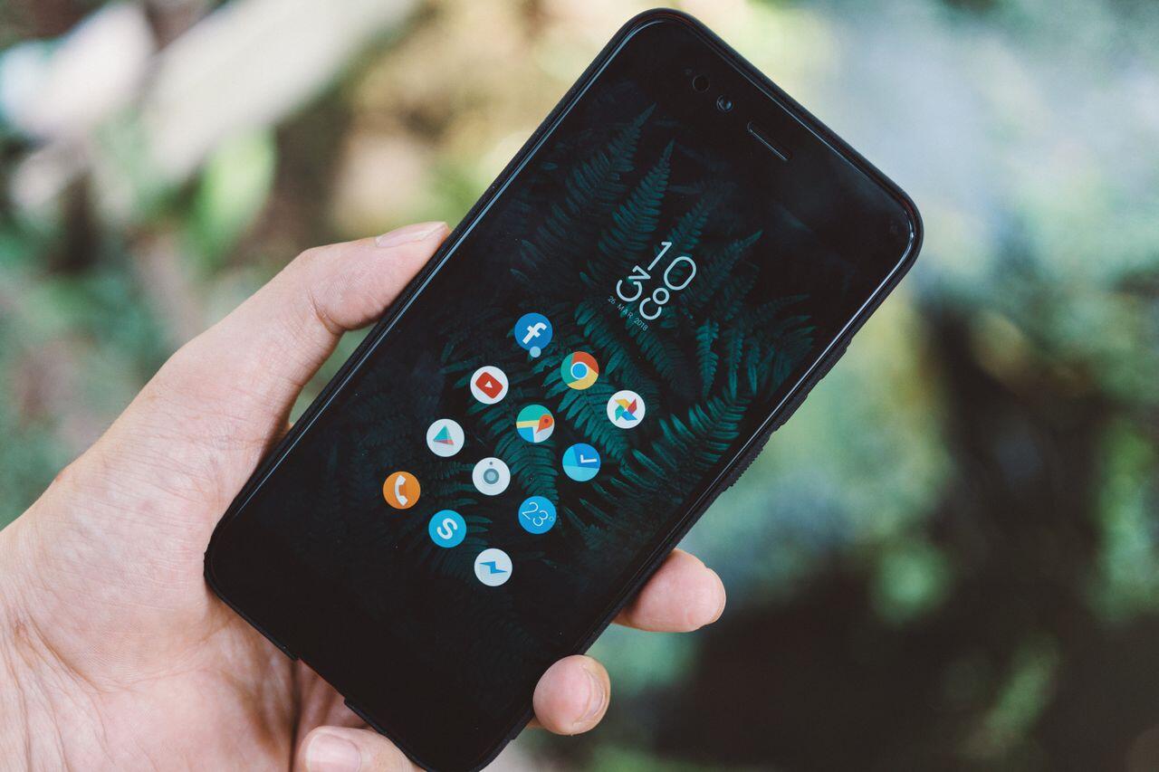 smartphone ouvert tenue dans une main dehors