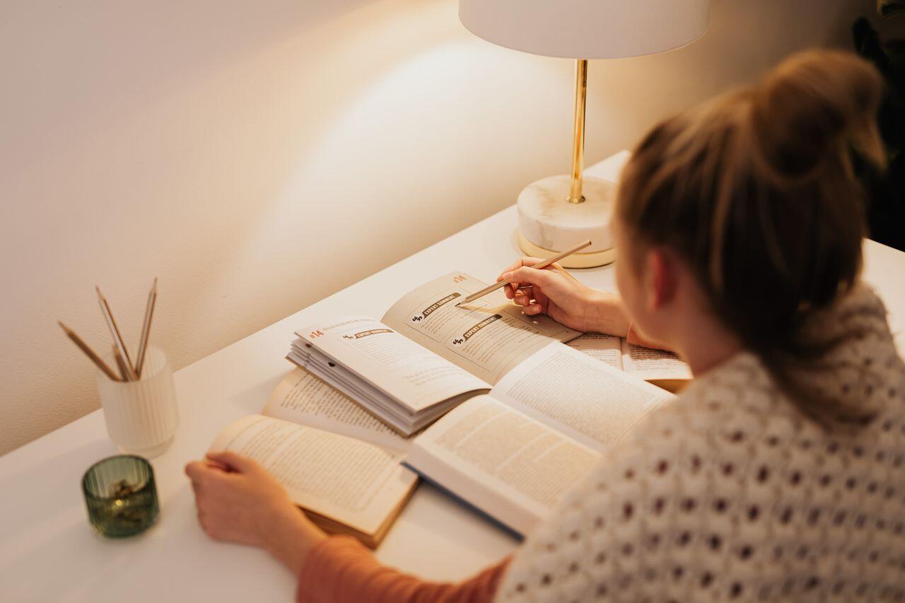 jeune femme etudiant a la lampe de bureau