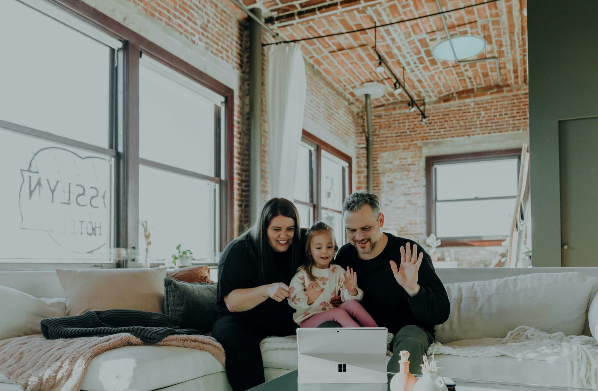 deux parents et leur fille a la maison devant le laptop