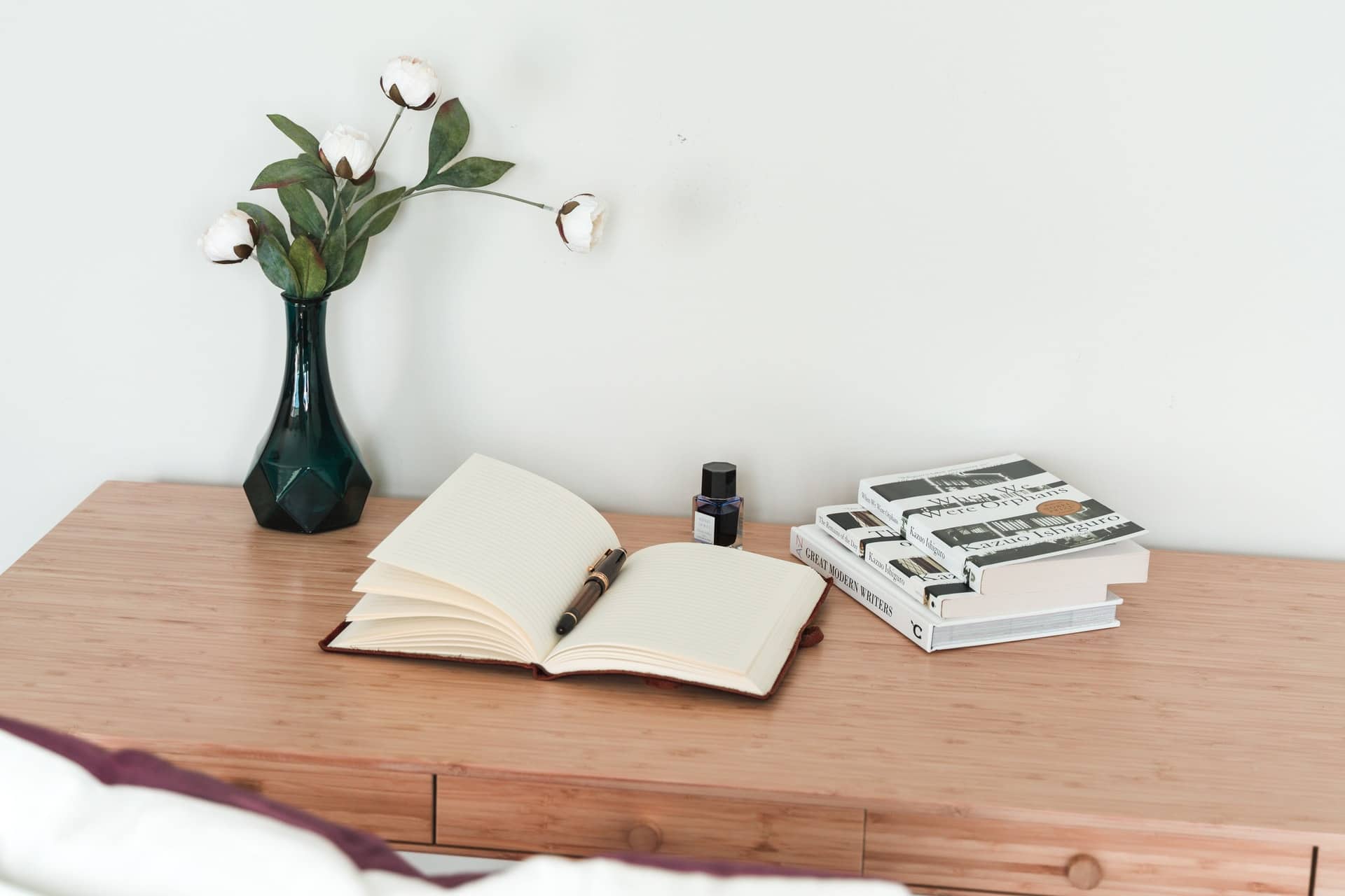 carnet, livres, stylo et plante sur une table