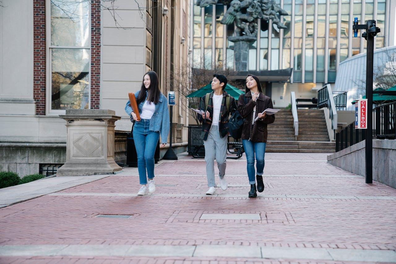 trois etudiants sortant de leurs cours avec les livres dans les mains