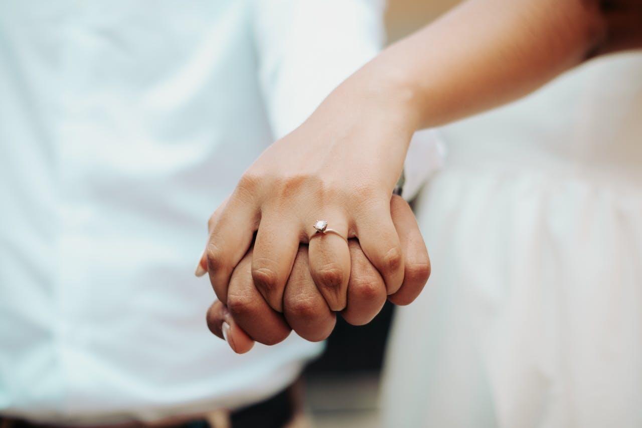 mains entrelacees d un couple avec bague