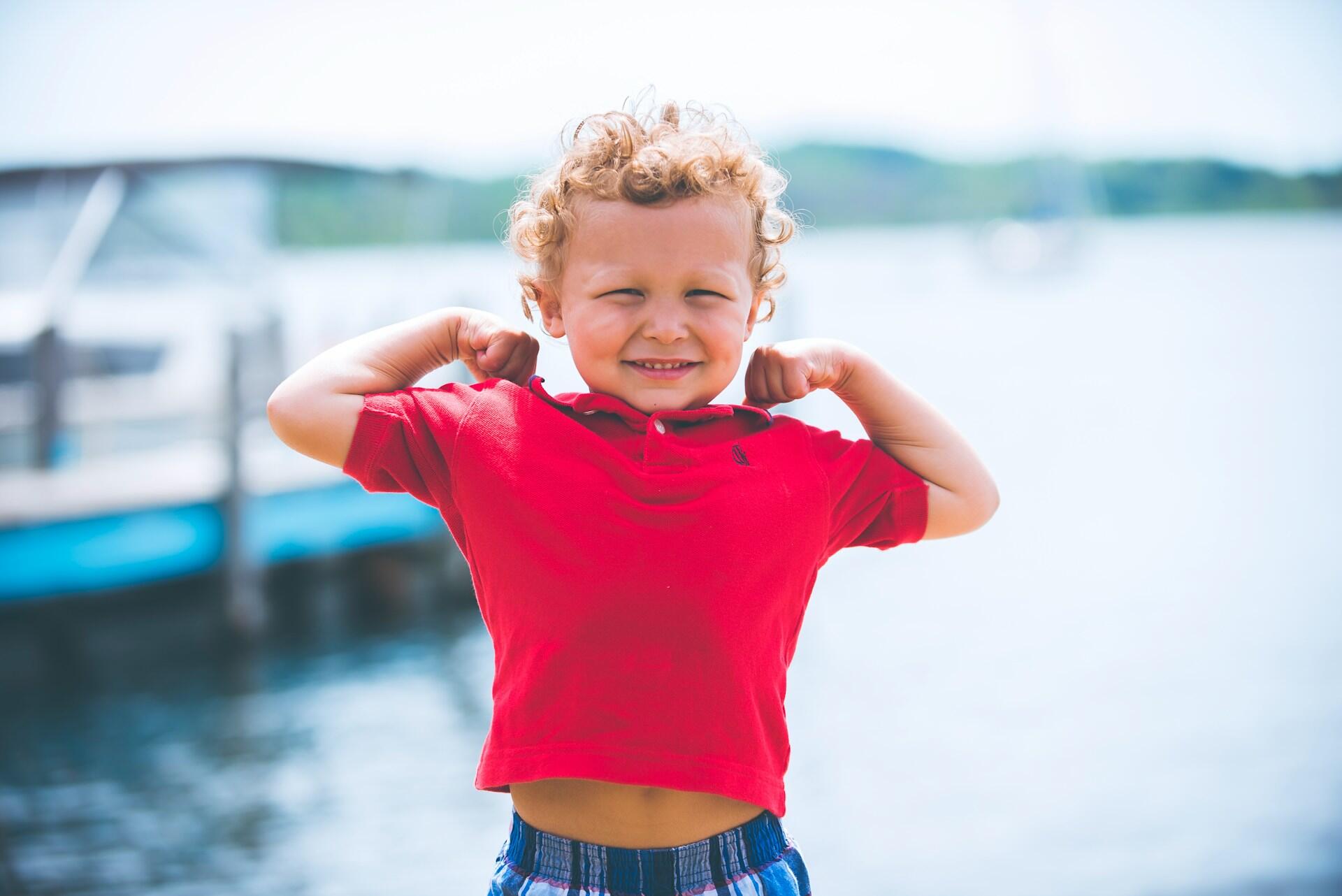 Un enfant qui montre ses muscles.