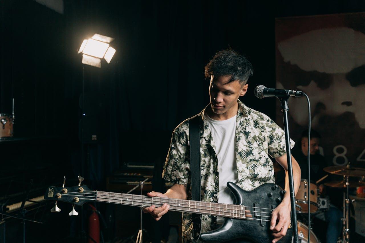 jeune homme chantant et jouant de la guitare sur scene