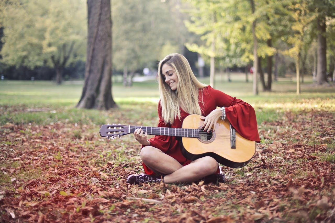 jeune femme jouant de la guitare dans les bois