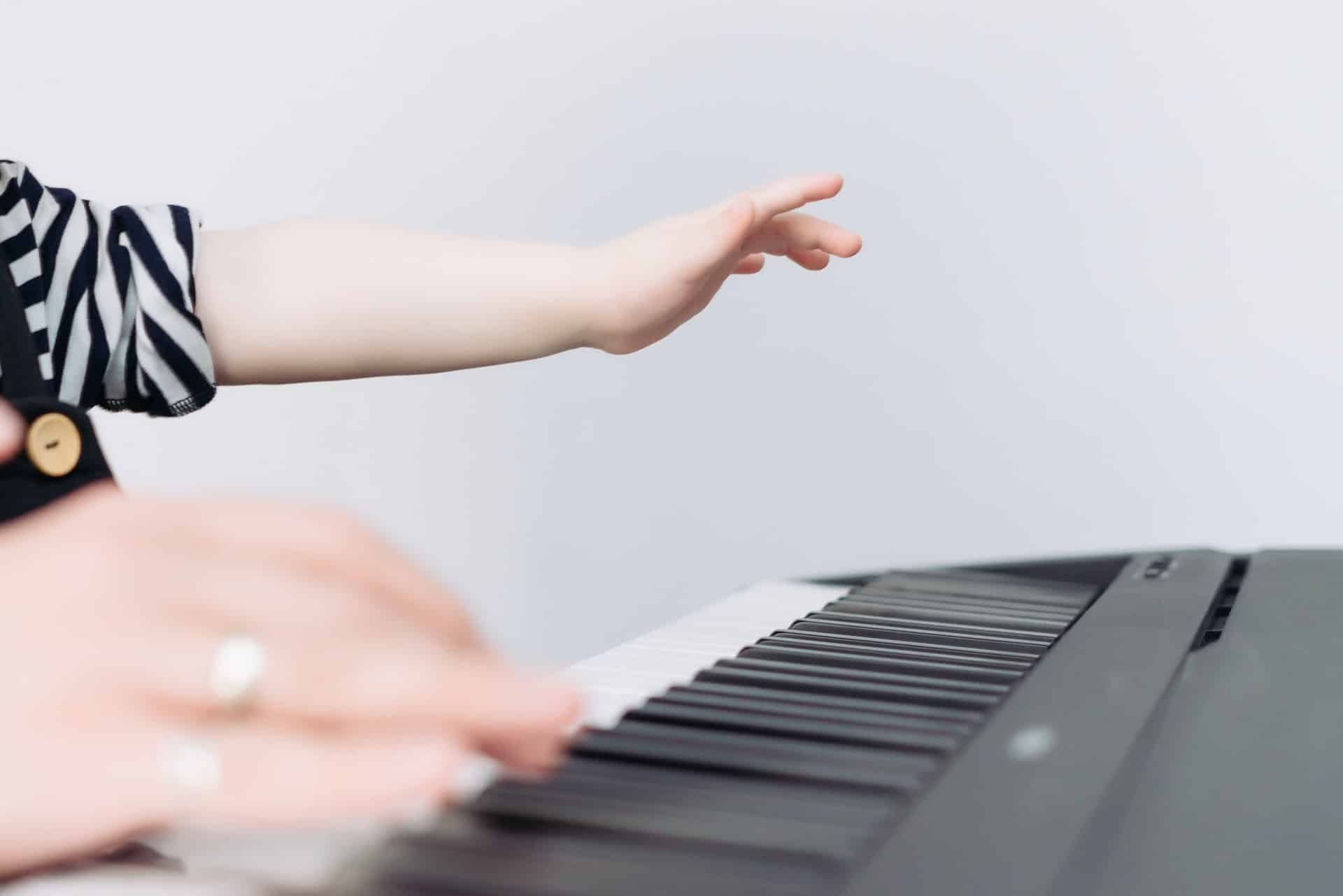 main de bébé au dessus d'un piano