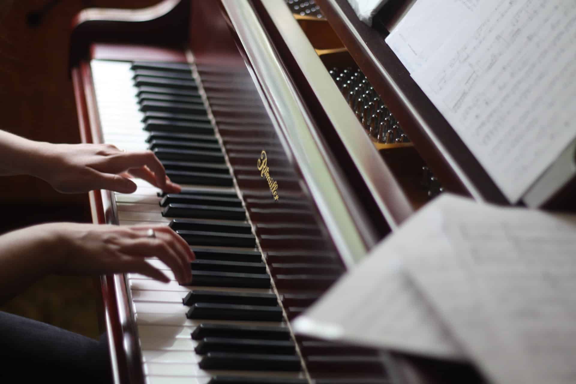 une femme en train de jouer du piano avec des partitions