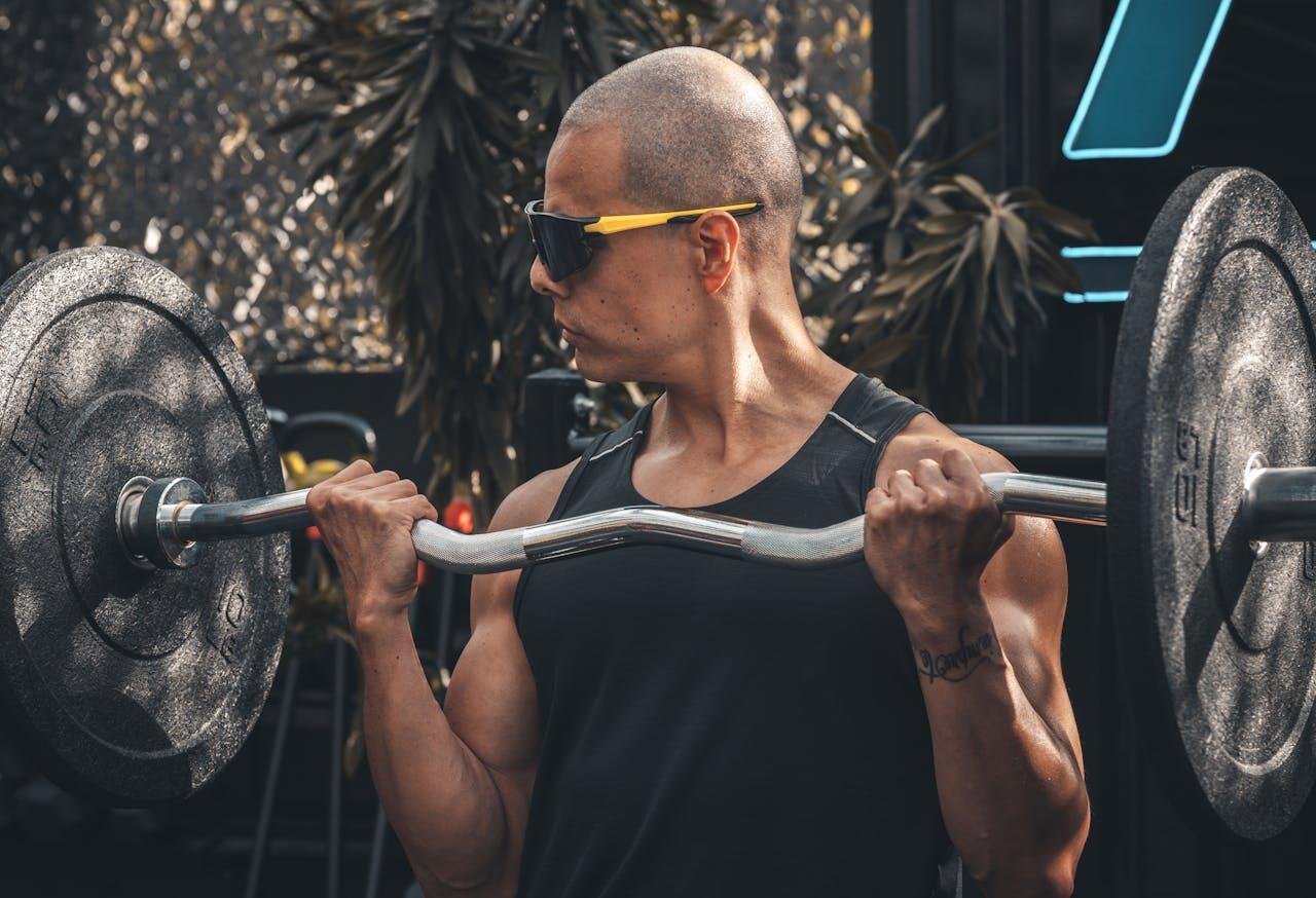 homme a lunettes de soleil et maillot de corps avec une barre ez