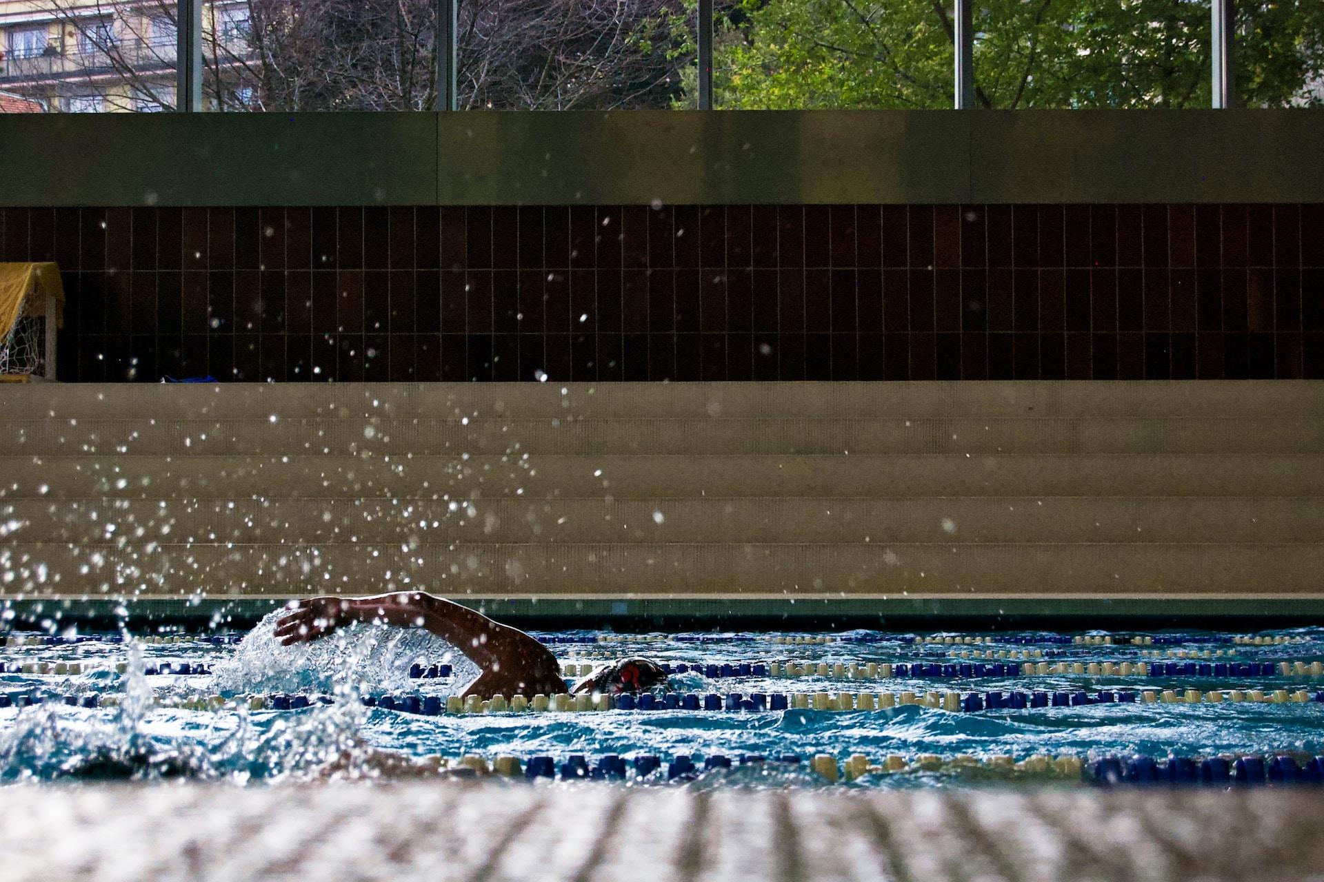 Une personne qui nage à la piscine.