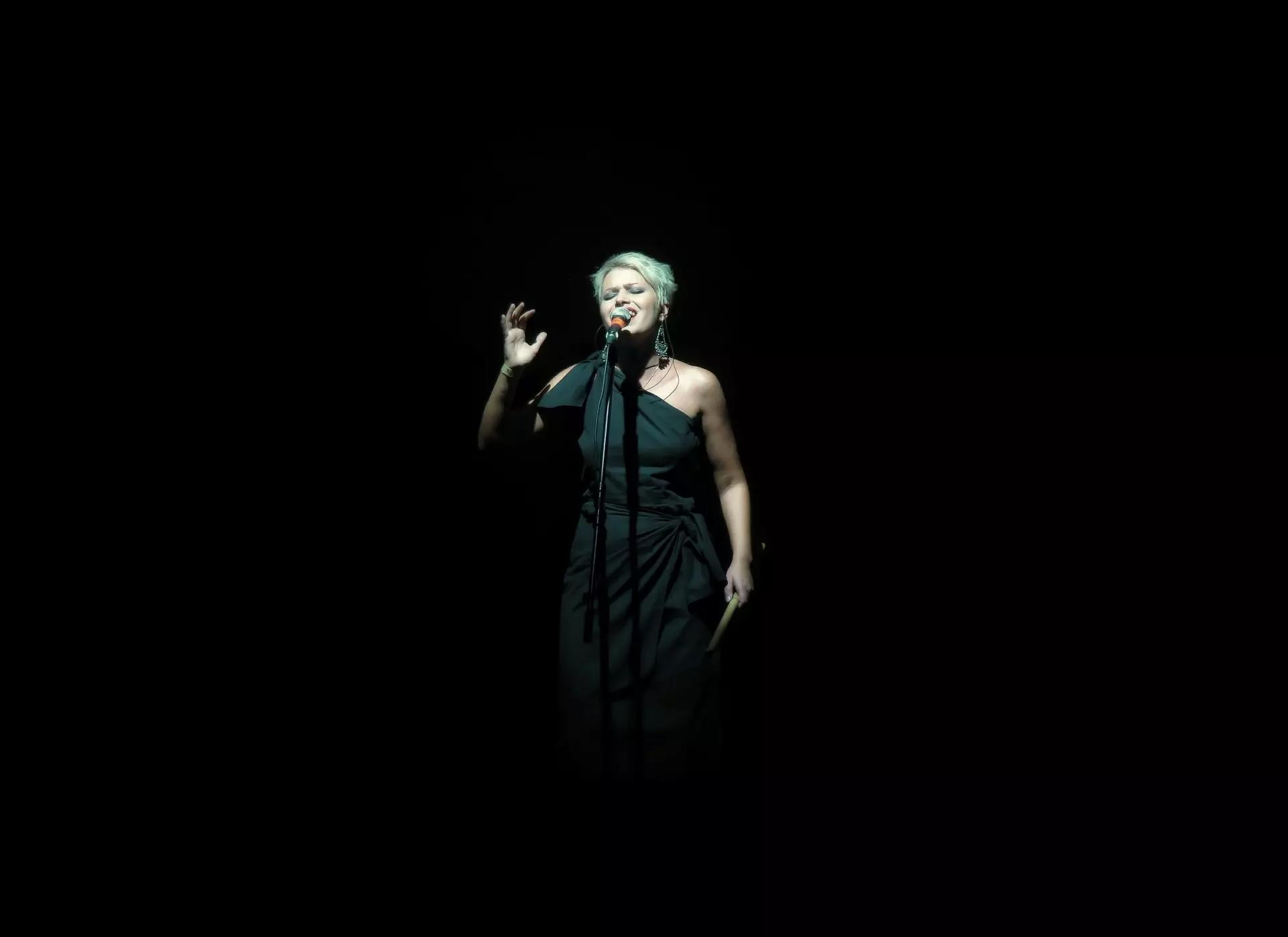 chanteuse sur scene avec fond noir