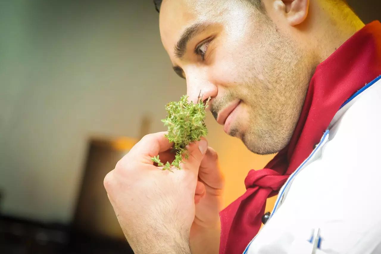chef qui sent des herbes aromatiques