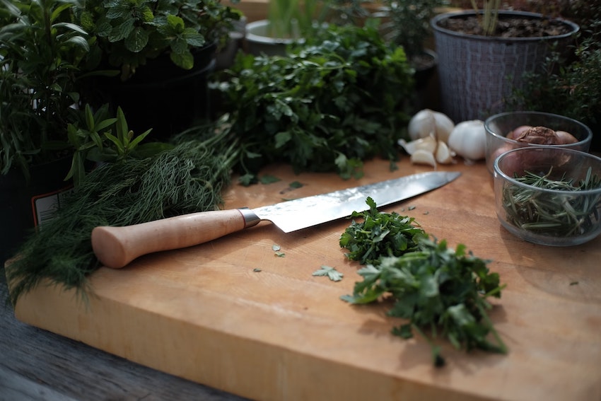 couteau et aromates sur une planche à découper