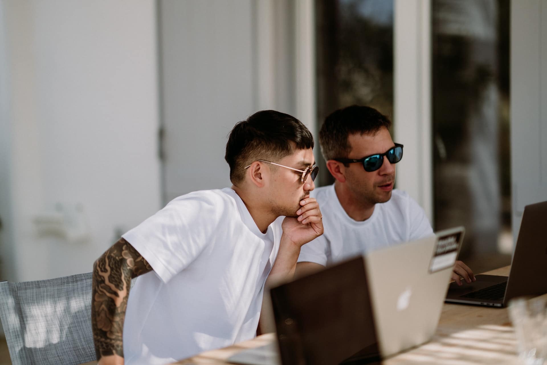 deux hommes travaillant ensemble sur un ordinateur