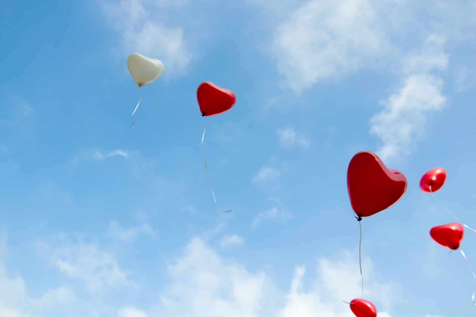 ballons en forme de coeur volant dans le ciel bleu