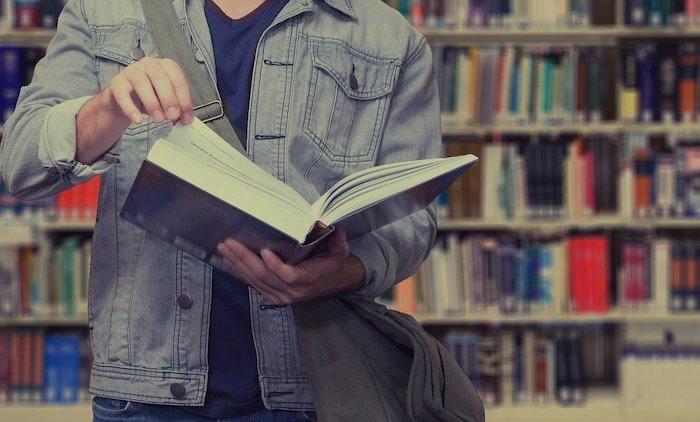 Un étudiant feuillete un livre