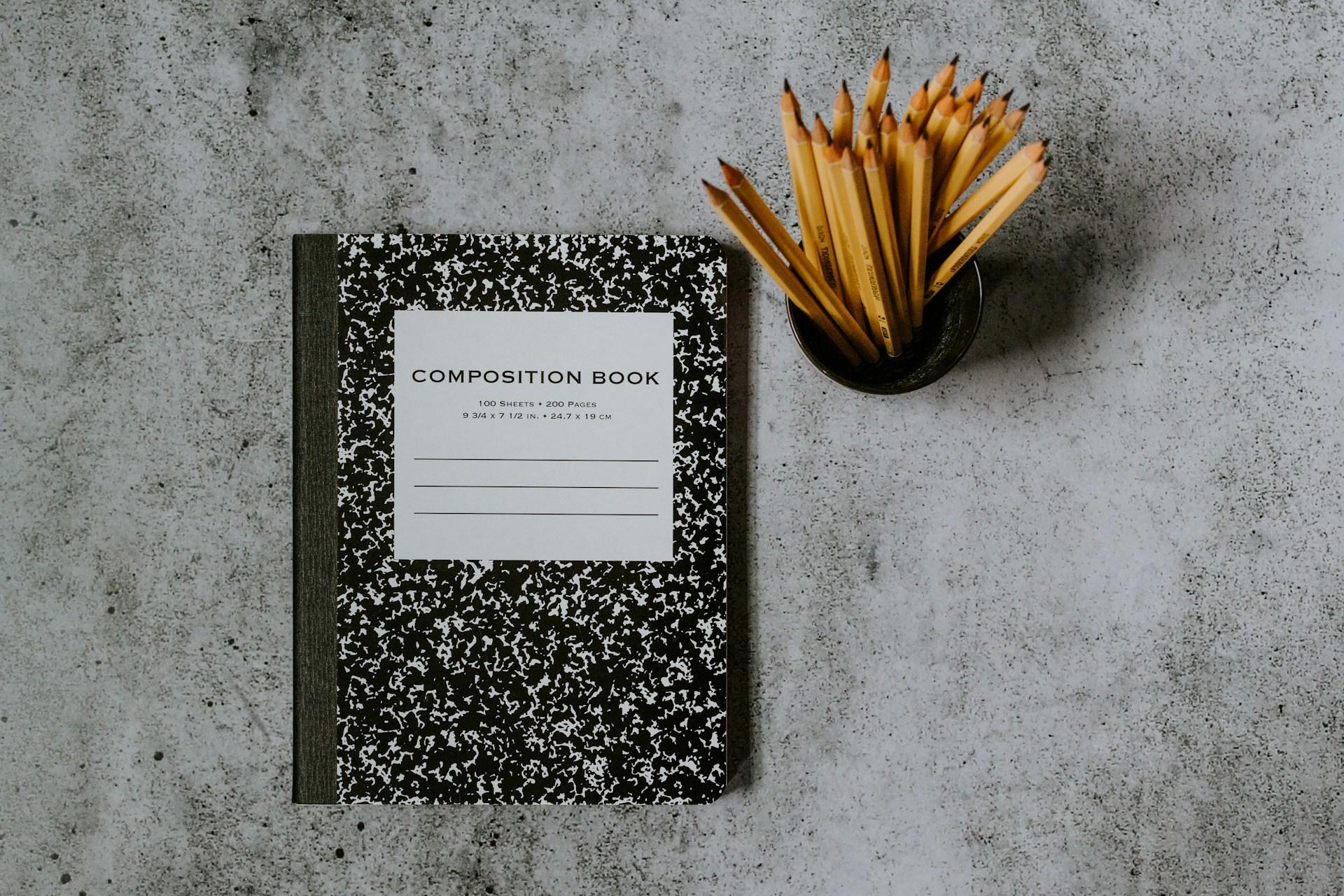 cahier noir carnet avec crayons en pot