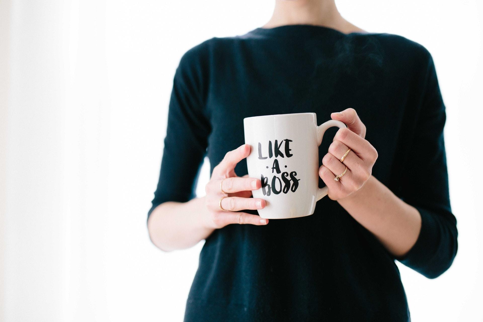 jeune femme tenant dans ses mains une tasse avec l'inscription "like a boss"