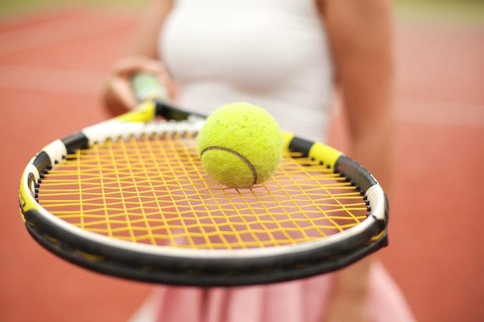 Une femme tient une raquette de tennis