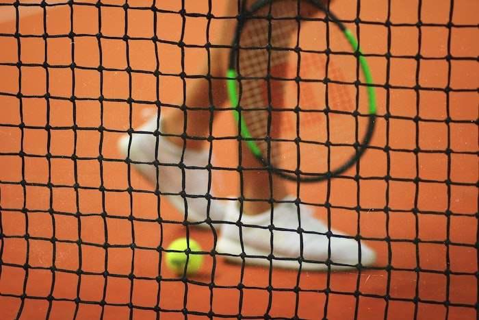Un joueur de tennis derrière le filet