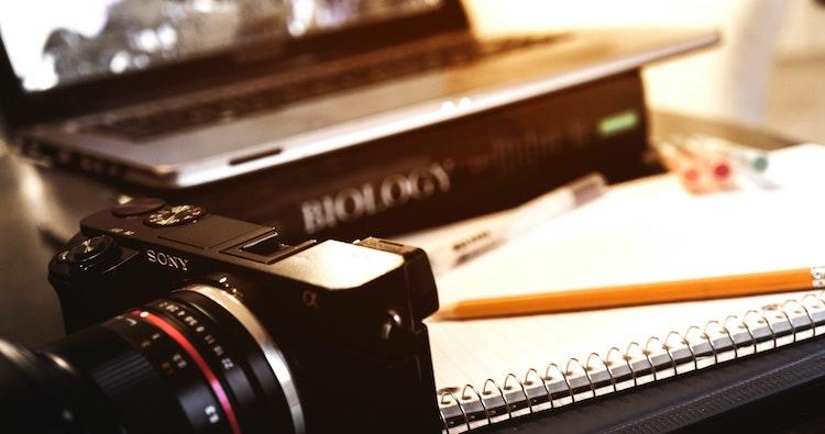 Appareil photo, livre de biologie et ordinateur