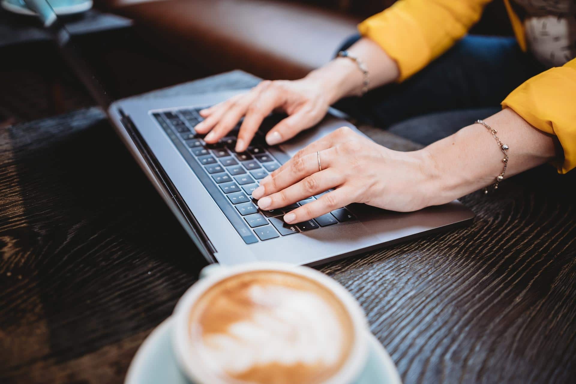 jeune femme travaillant sur un ordinateur avec un café
