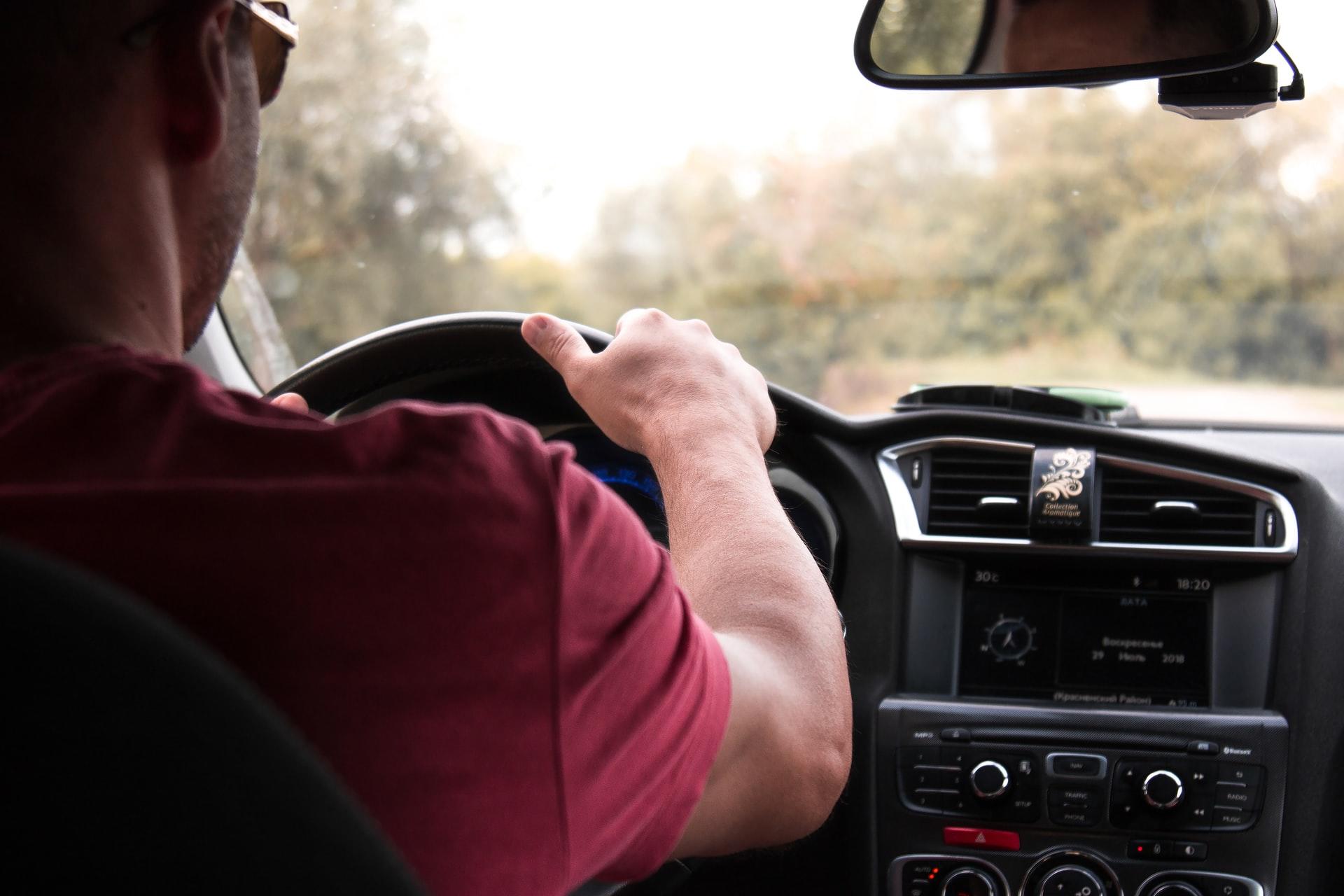 homme avec lunettes de soleil conduisant sa voiture