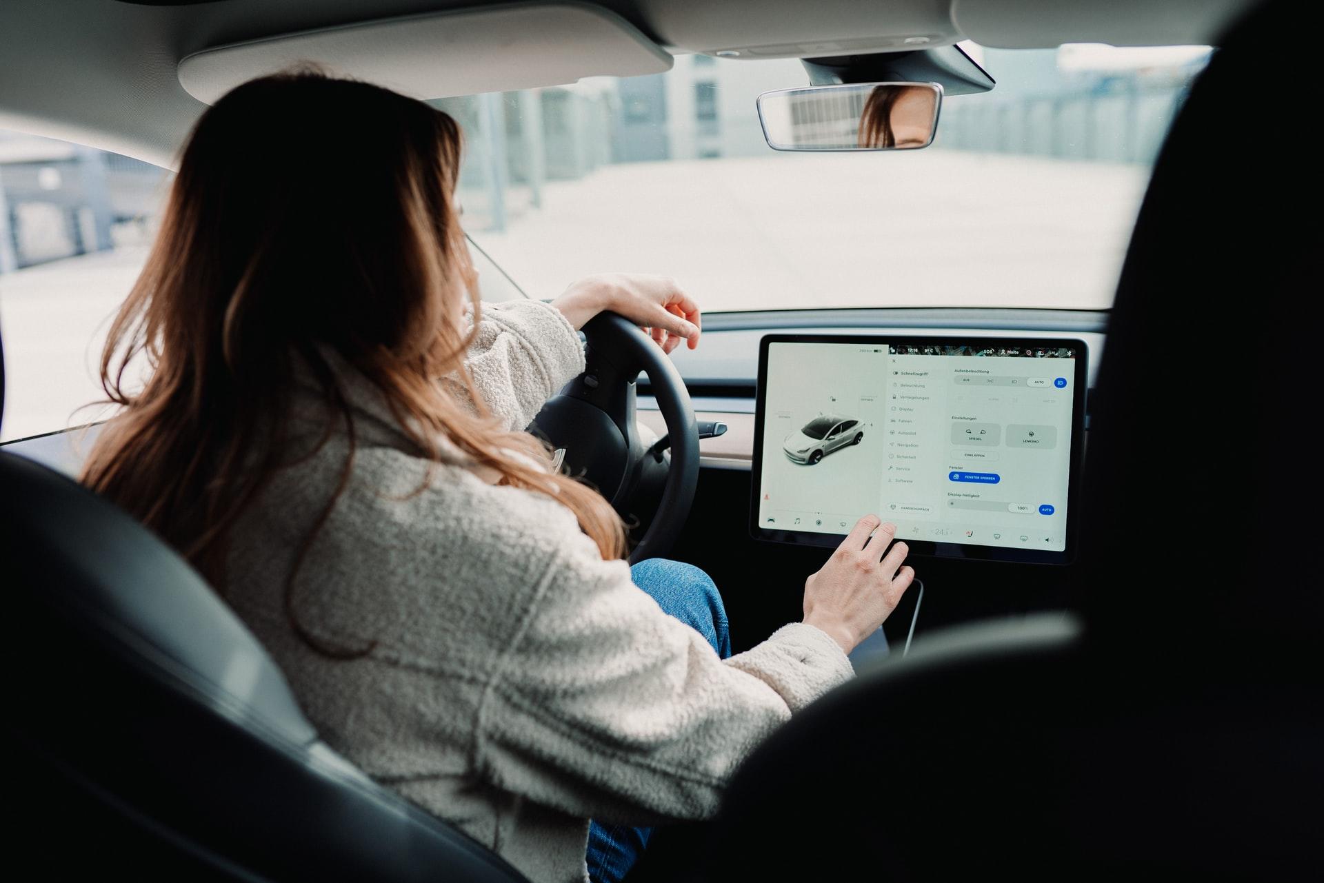 jeune femme au volant avec un très grand GPS