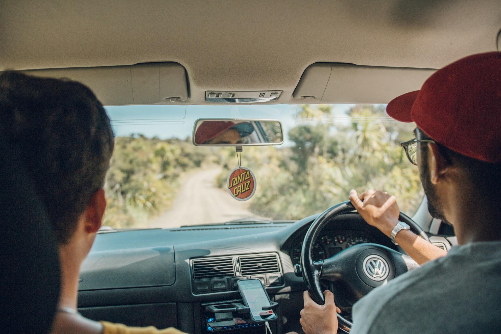Homme avec une casquette rouge conduisant une voiture