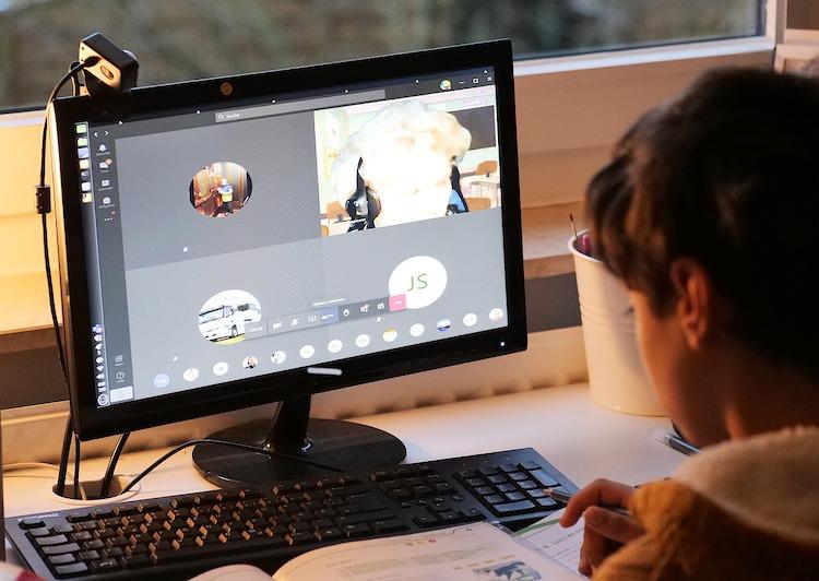 Un enfant suit un cours en visio