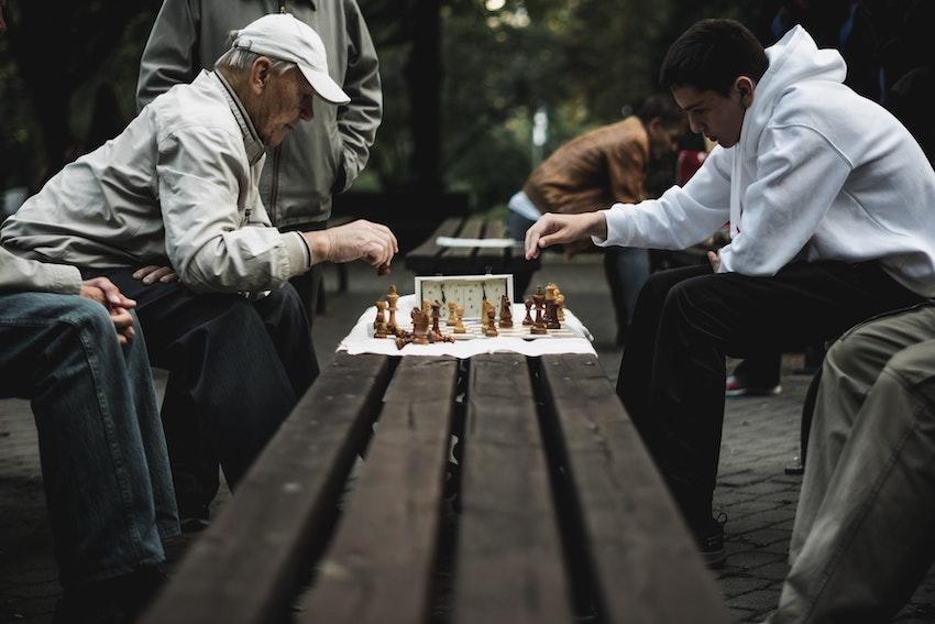 un jeune homme et un monsieur en train de jouer aux échecs