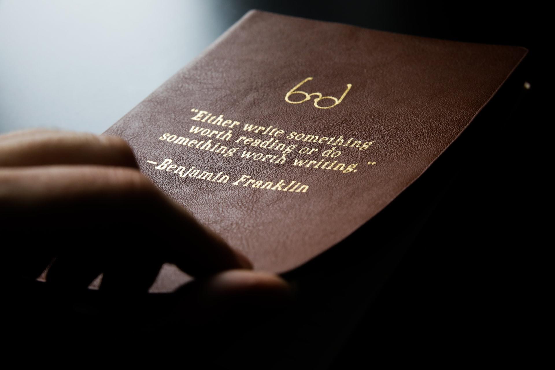citation de benjamin franklin sur une page couverture en cuir