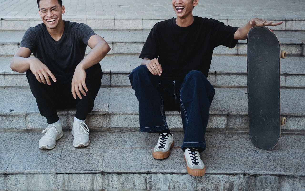 jeunes avec un skate riant aux éclats