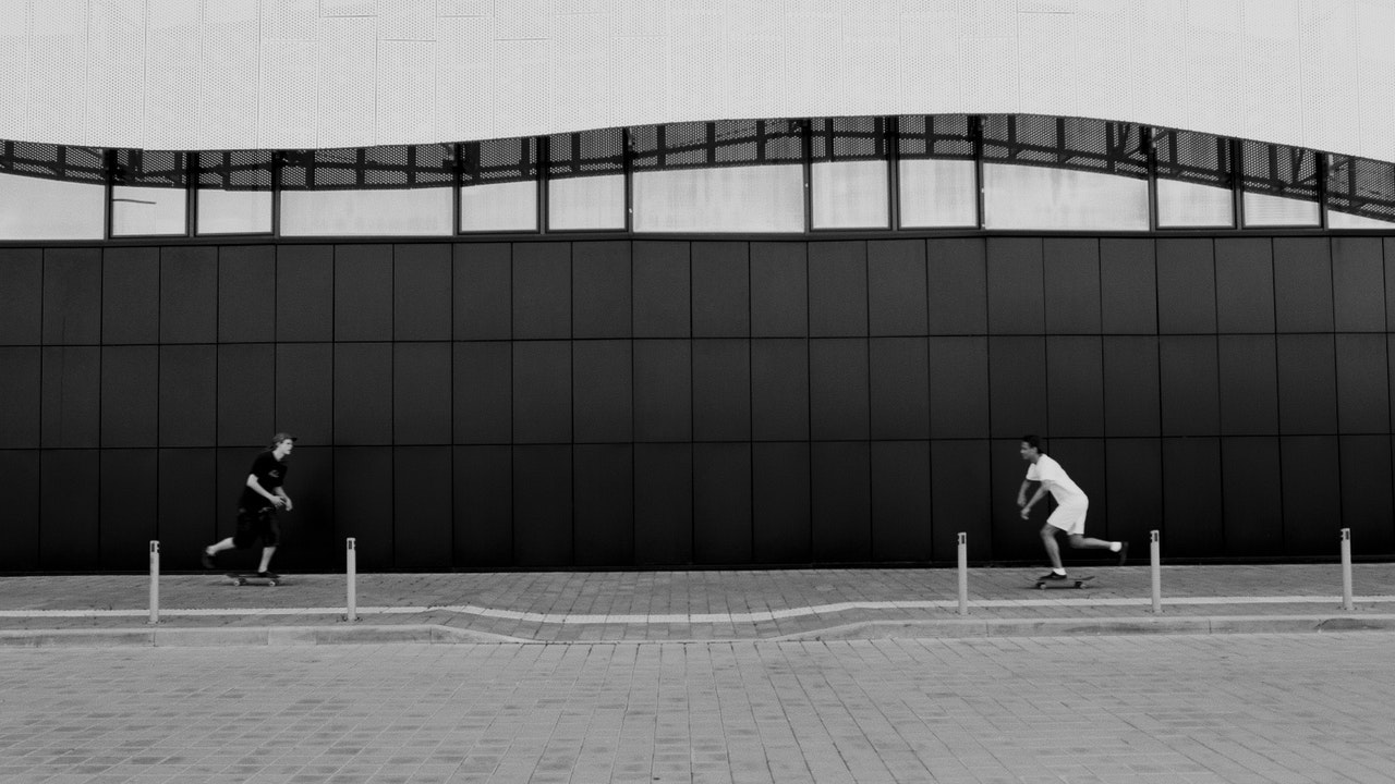image en noir et blanc de deux skateurs roulant l'un vers l'autre