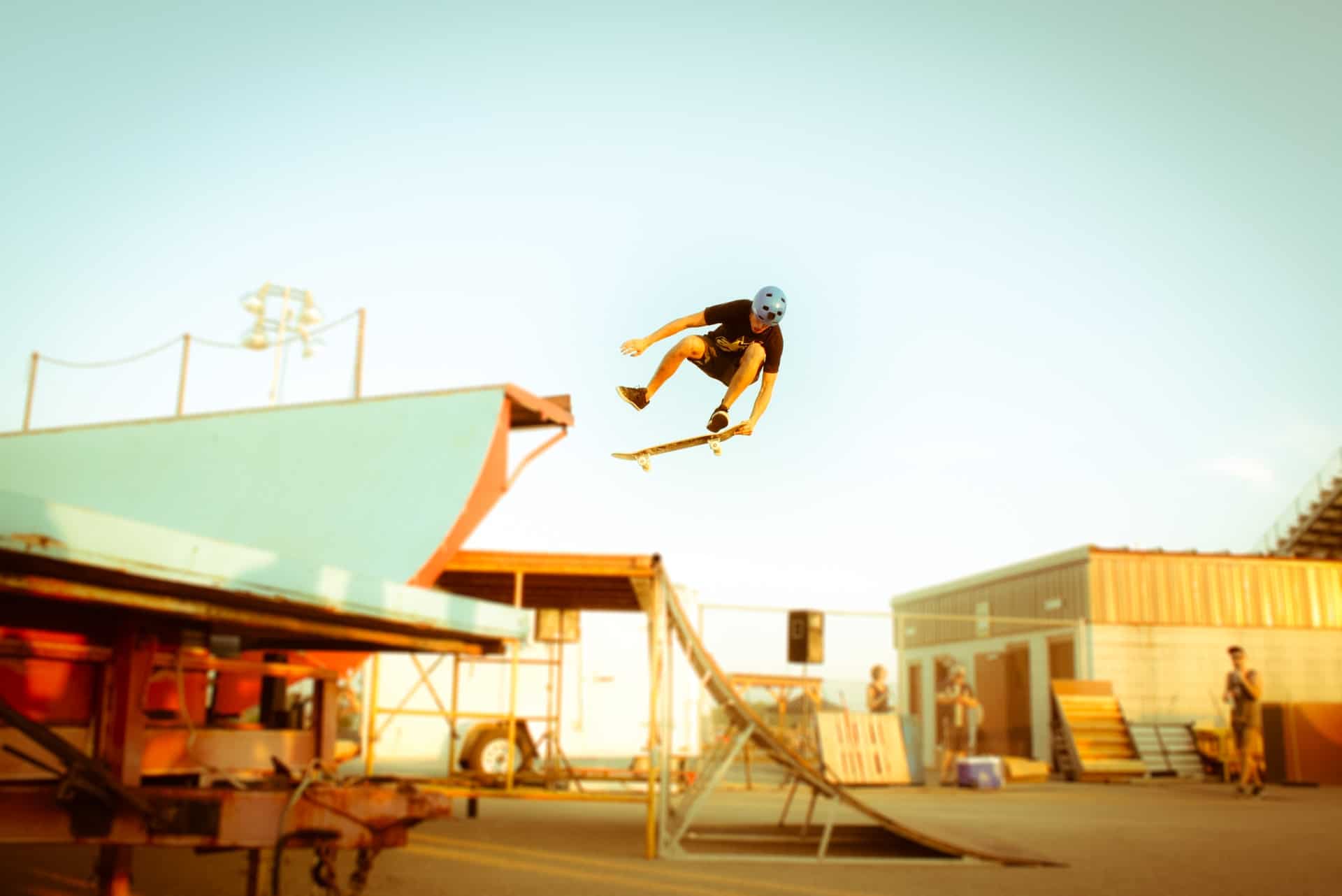 jeune homme en casque effectuant un saut avec son skate