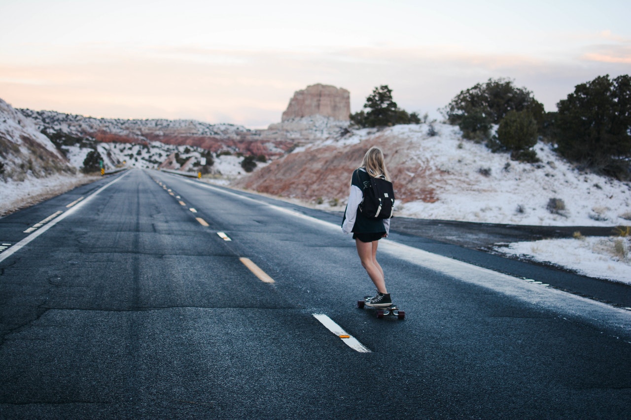 jeune femme roulant en skate sur le bord de la route