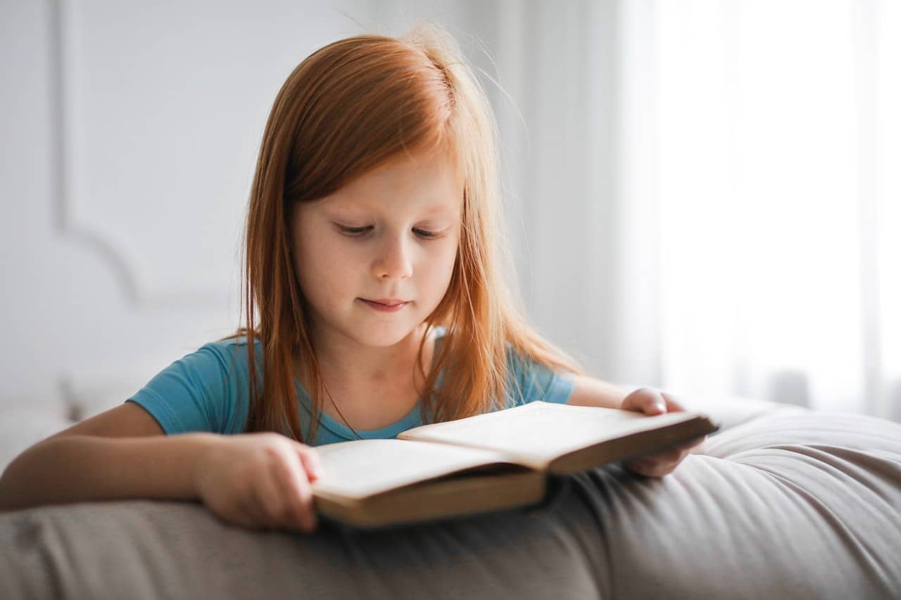 enfant rousse lisant un livre