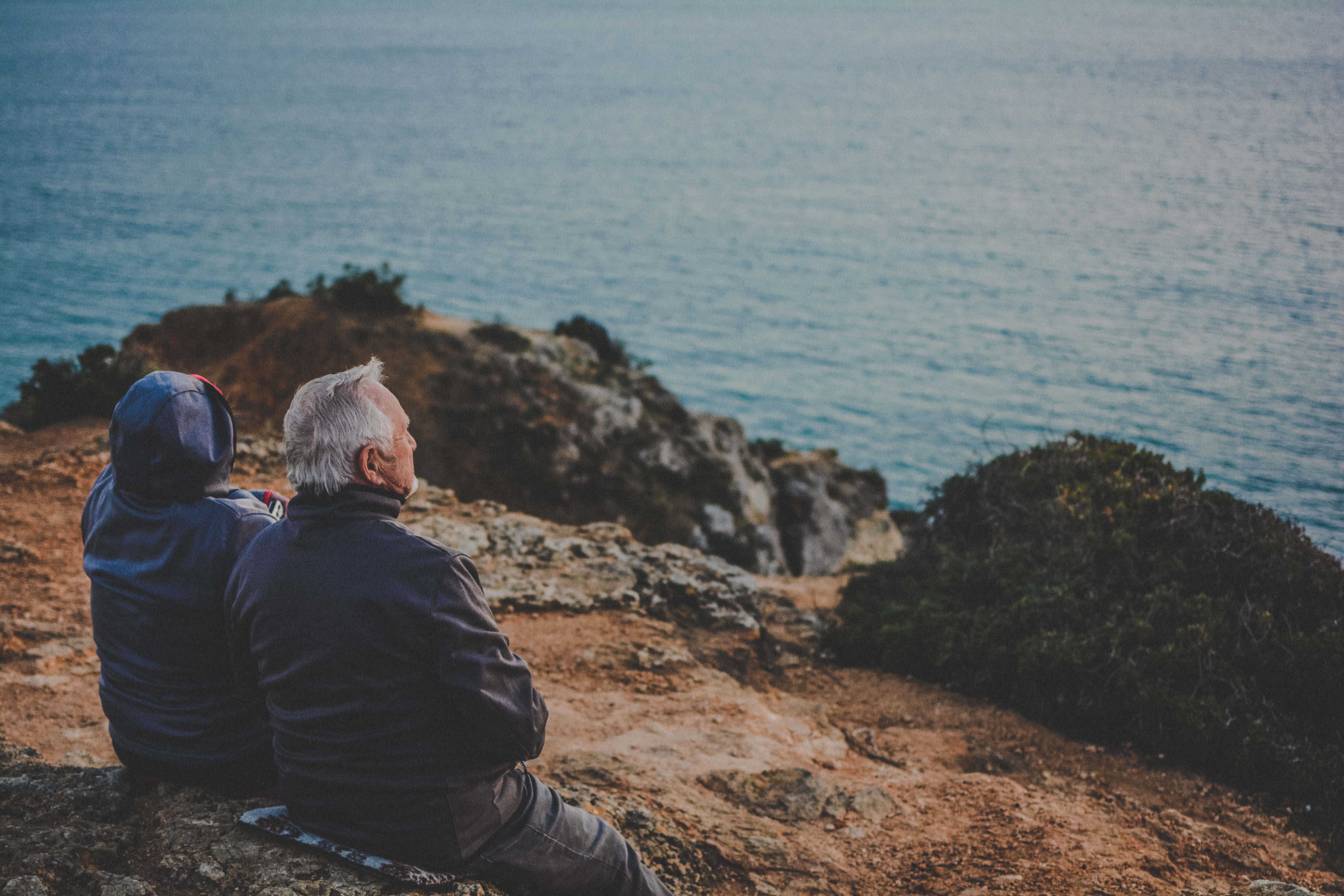 deux personnes admirent un paysage au bord de la mer