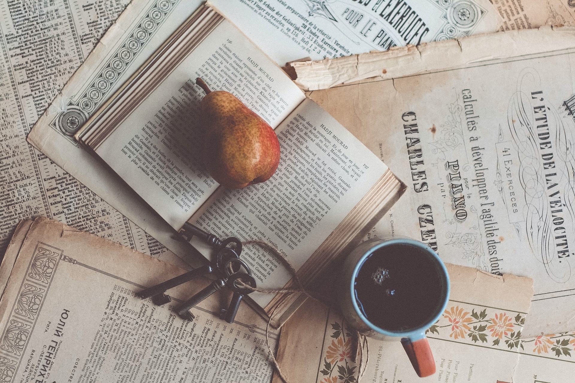 poire, clés et tasse de café sur des partitions