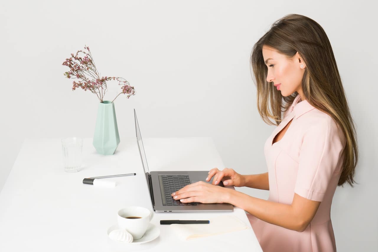 femme d'affaire en rose travaillant sur son laptop